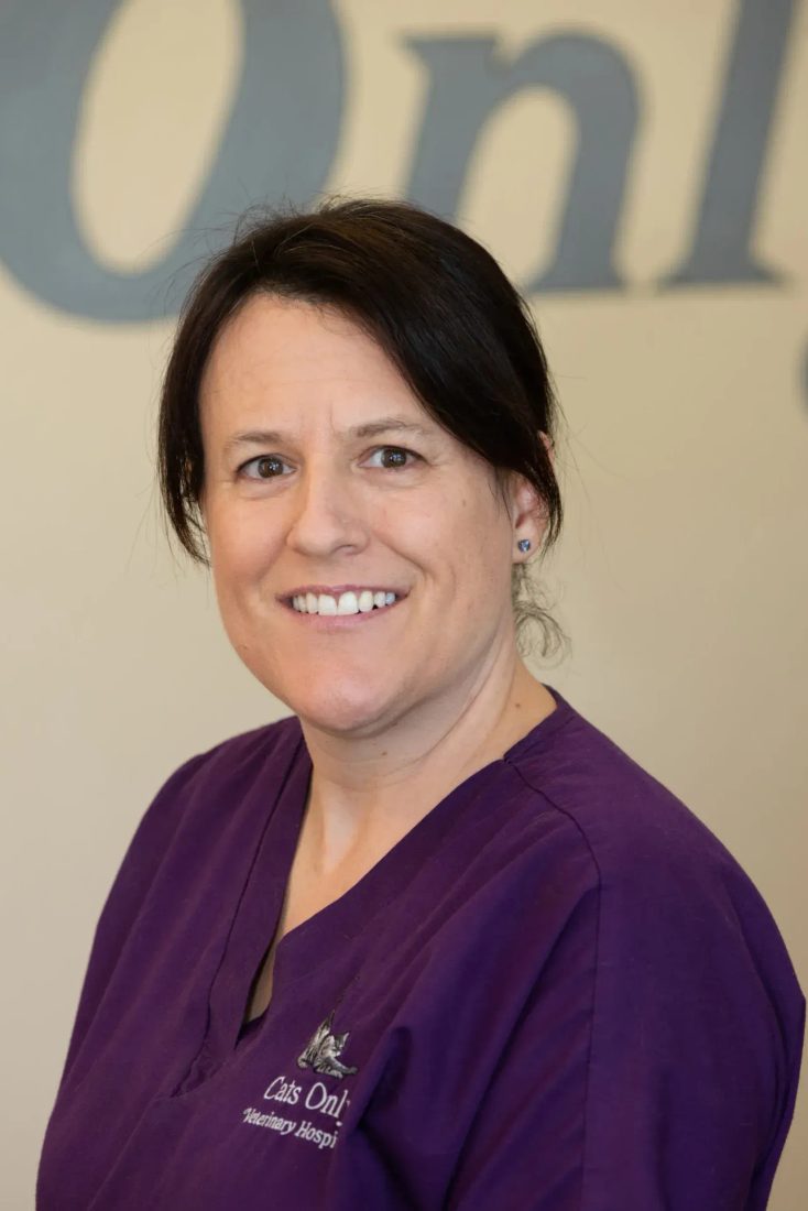 Smiling staff member in purple scrubs at Cats Only Veterinary Hospital